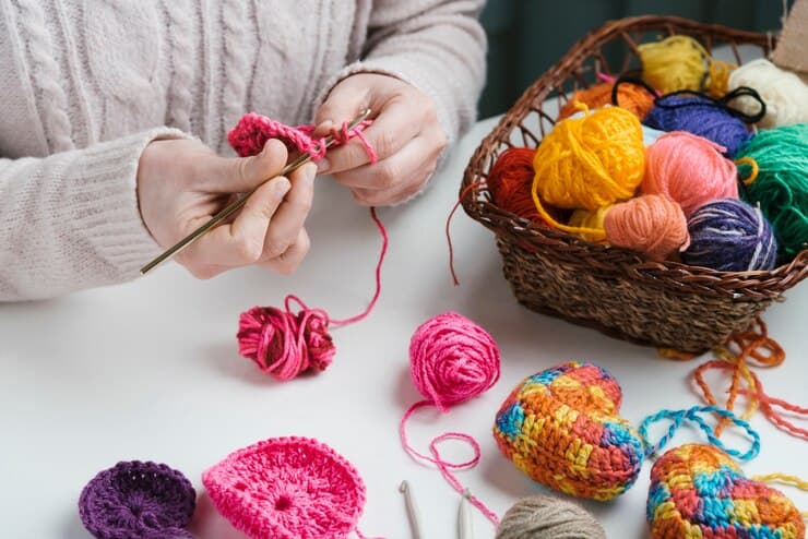 Women Knitting Near a Basket With Colorful Yarn