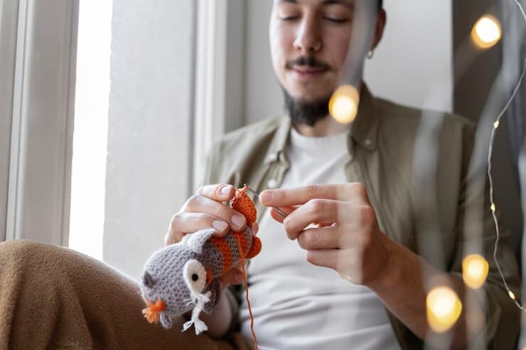 Young Man Knitting a Toy